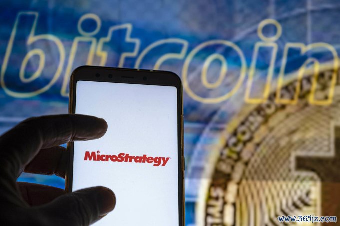 Logo MicroStrategy được đặt trước ảnh nền minh họa về Bitcoin. Ảnh: CNBC